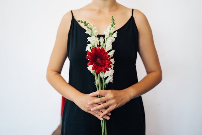 A Person in Black Dress Holding a Bunch of Flowers